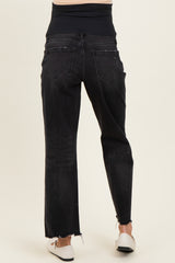 woman wearing black maternity jeans with a high waist and distressed hem, showing the back view