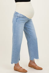 woman wearing light blue maternity jeans with a high elastic waistband and frayed hem, showing a baby bump