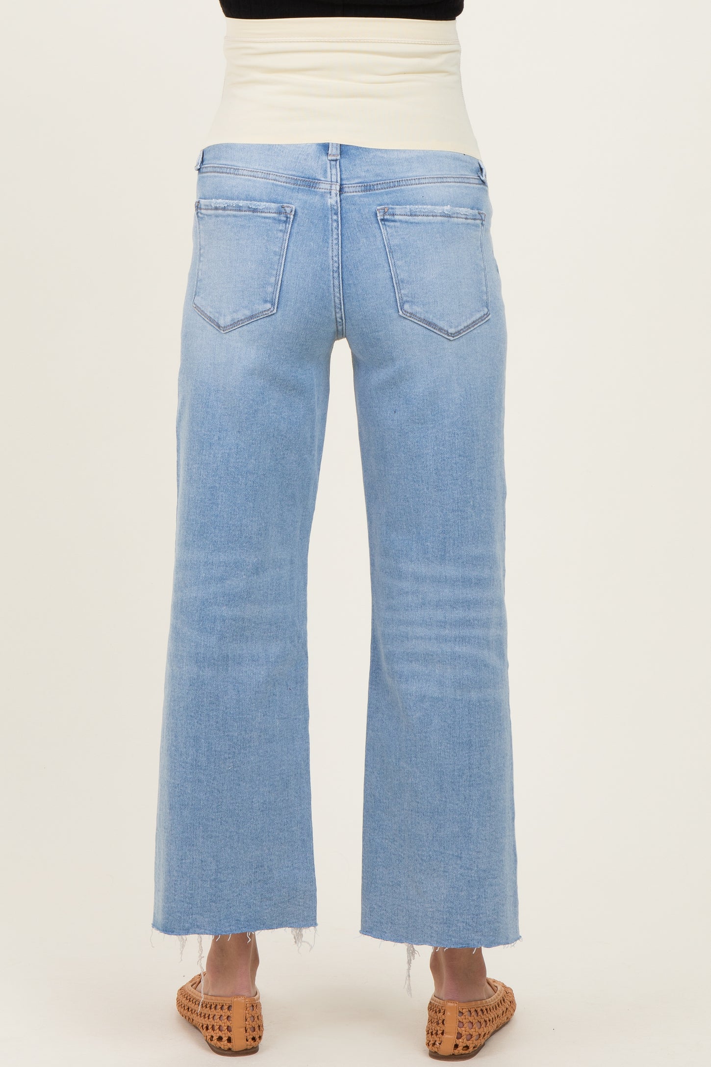 maternity wear light blue wide leg jeans with a stretchy waistband and frayed hem, shown from the back