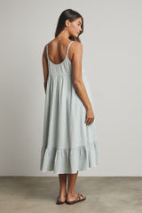 woman wearing a light green checkered midi dress with a flounced hem and spaghetti straps, viewed from the back