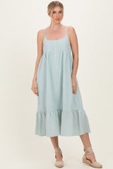 woman wearing a green and white gingham midi dress with adjustable straps and a ruffled hem