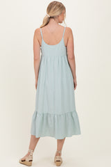 woman wearing a light green gingham midi dress with a tiered ruffle hem and adjustable straps, shown from the back