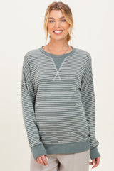 woman wearing a green striped maternity sweatshirt with long sleeves and a relaxed fit, showing her baby bump