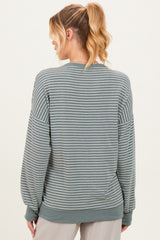 woman wearing a green striped maternity sweatshirt with long sleeves, shown from the back