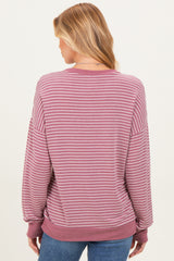 woman wearing a mauve and white striped maternity sweatshirt with a relaxed fit seen from the back