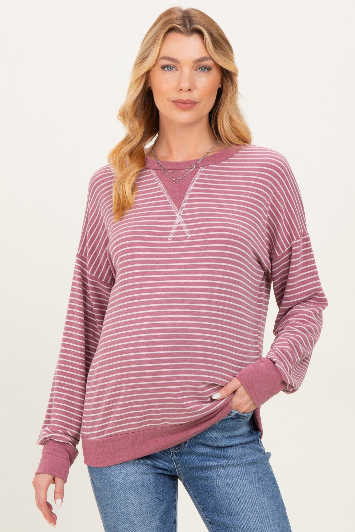 woman wearing a burgundy and white striped maternity sweatshirt with a relaxed fit and long sleeves