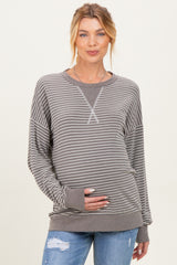 woman wearing a gray striped maternity sweatshirt and holding her baby bump