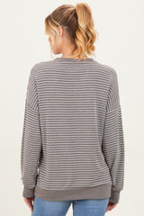 woman wearing a gray striped maternity sweatshirt seen from the back, with loose fit and long sleeves