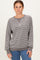 woman wearing a gray striped long sleeve sweatshirt with a relaxed fit and ribbed cuffs paired with blue jeans