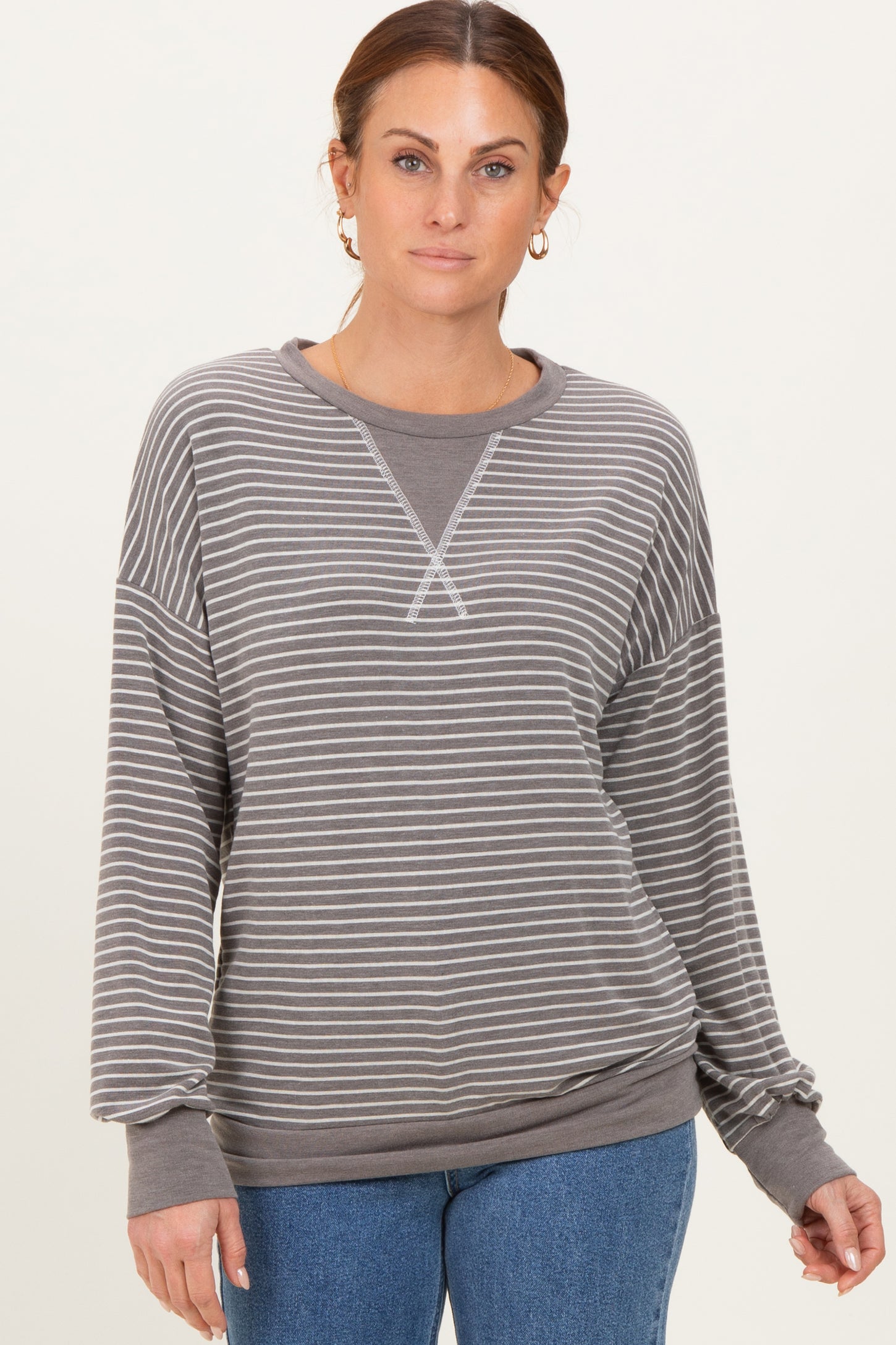 woman wearing a gray striped long sleeve sweatshirt with a relaxed fit and ribbed cuffs