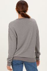 woman wearing a gray and white striped long sleeve oversized sweatshirt, viewed from the back