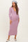 woman wearing a lavender ribbed maternity dress with a deep v-neck and long sleeves, showcasing her baby bump