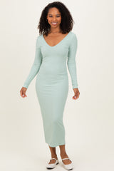 woman wearing a light green ribbed long sleeve maxi dress with a v-neckline and smiling