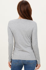 woman wearing a grey long sleeve top, viewed from the back, paired with blue jeans