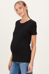 woman wearing a black short sleeve maternity top and showing her baby bump