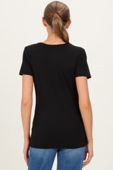 woman wearing a black short sleeve maternity top, seen from the back with her hair pulled back
