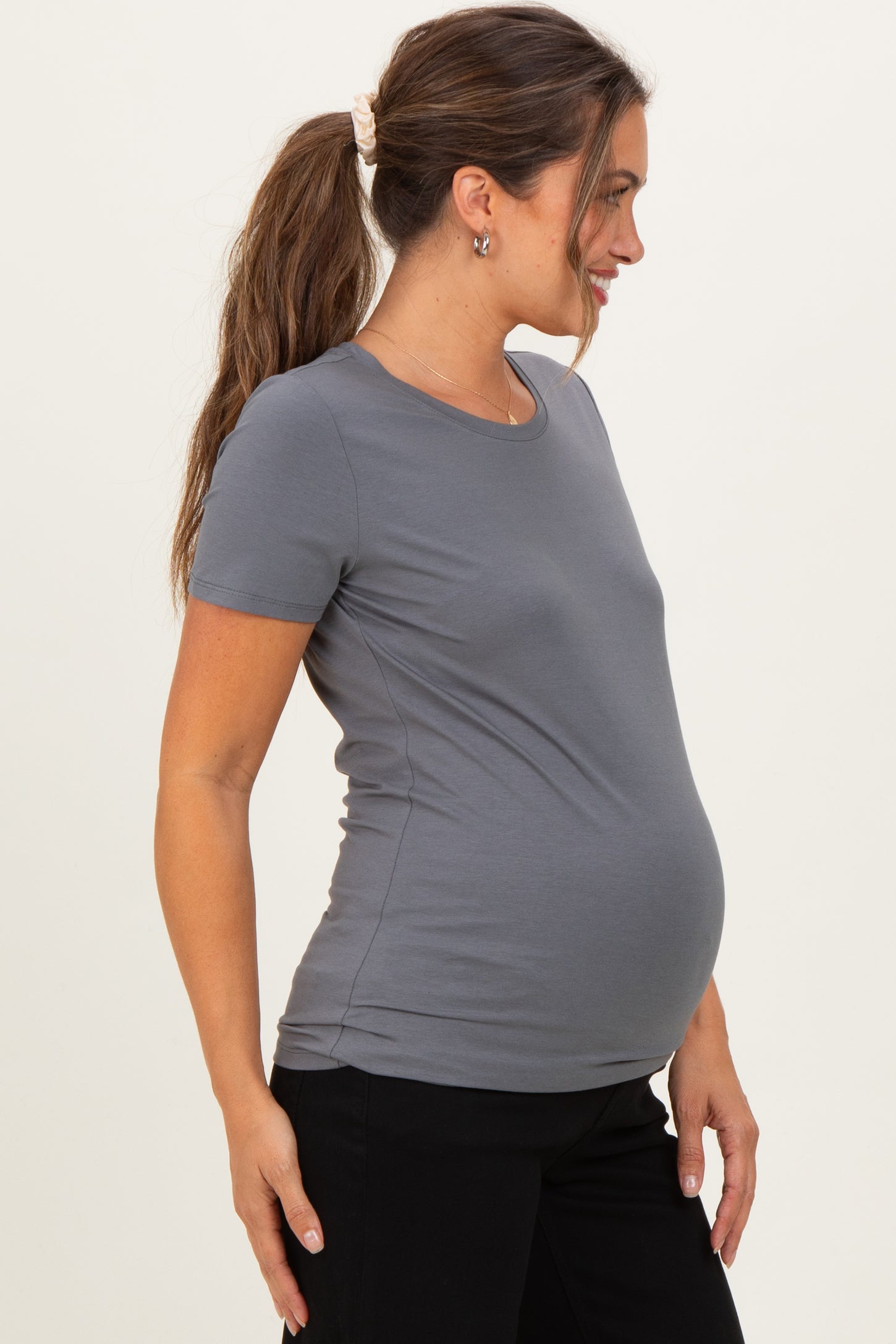woman wearing a grey short sleeve maternity t-shirt, showing a visible baby bump