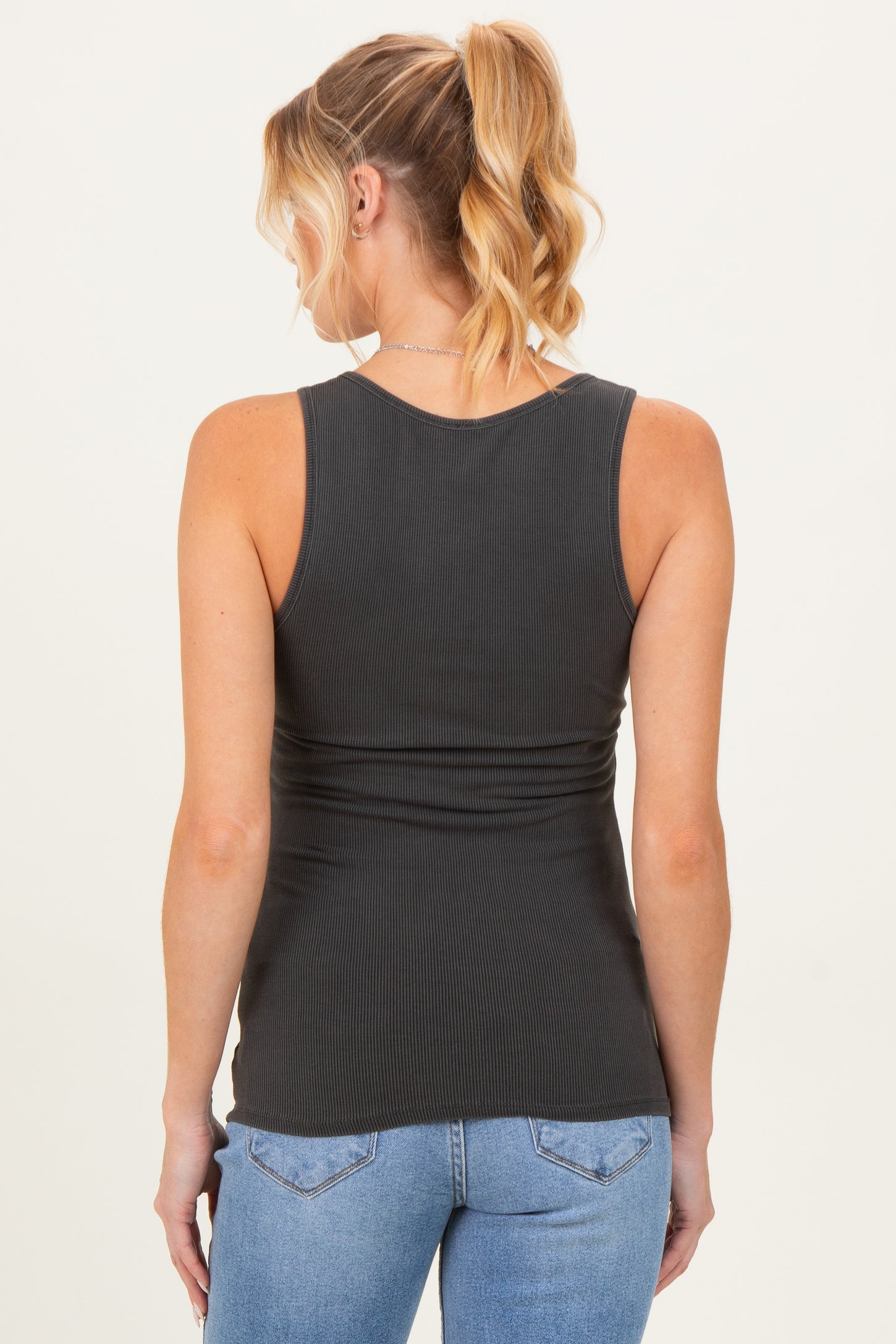 woman wearing a dark gray maternity tank top with a fitted style, showing a smooth back and no visible baby bump