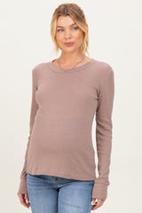 woman wearing a mauve long sleeve maternity top with a fitted style and visible baby bump