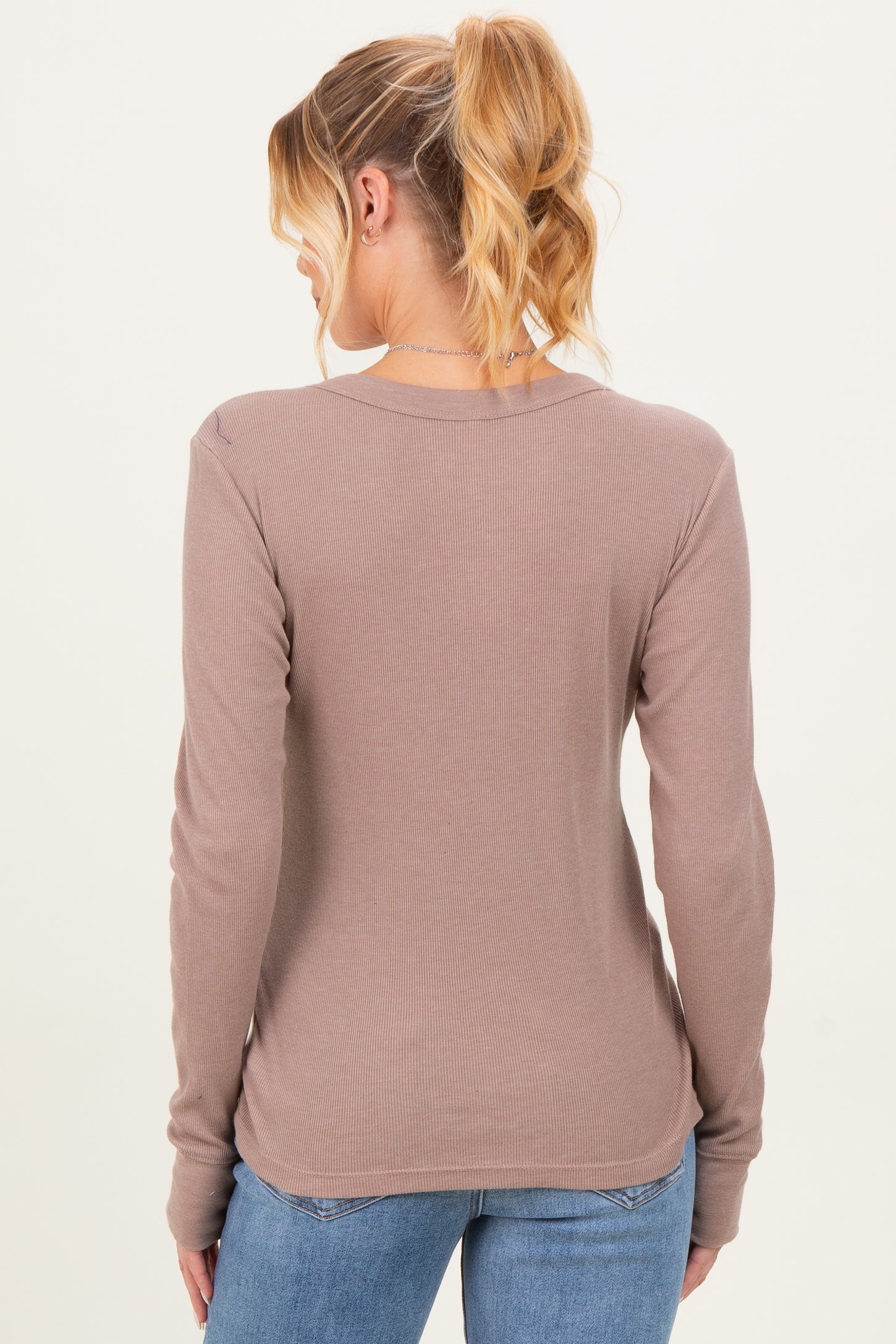 woman wearing a taupe long sleeve maternity top, seen from the back, with a ribbed texture and relaxed fit