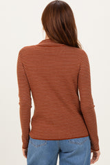 woman wearing a rust striped long sleeve top, seen from the back