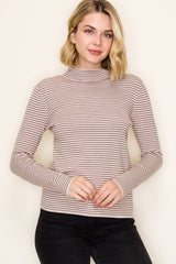 woman wearing a striped taupe long sleeve turtleneck top with a fitted style