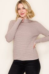 woman wearing a beige and brown striped long sleeve top with a high neckline and fitted style