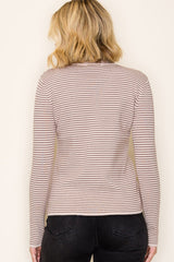 woman wearing a light beige striped long sleeve top and black jeans, viewed from the back