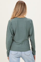 woman wearing a green back view long sleeve maternity top with a relaxed fit and dropped shoulders