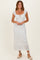 woman wearing a white floral midi dress with short puff sleeves and a front tie detail