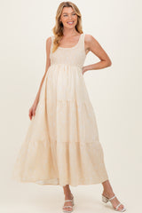 woman wearing a light yellow maternity maxi dress with a smocked bodice and tiered skirt, showcasing her baby bump