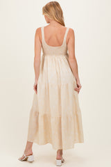 woman wearing a light beige maternity maxi dress with a smocked bodice and tiered skirt, showing her back