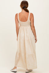 woman wearing a backless cream maxi dress with a smocked bodice and tiered skirt, standing against a neutral background