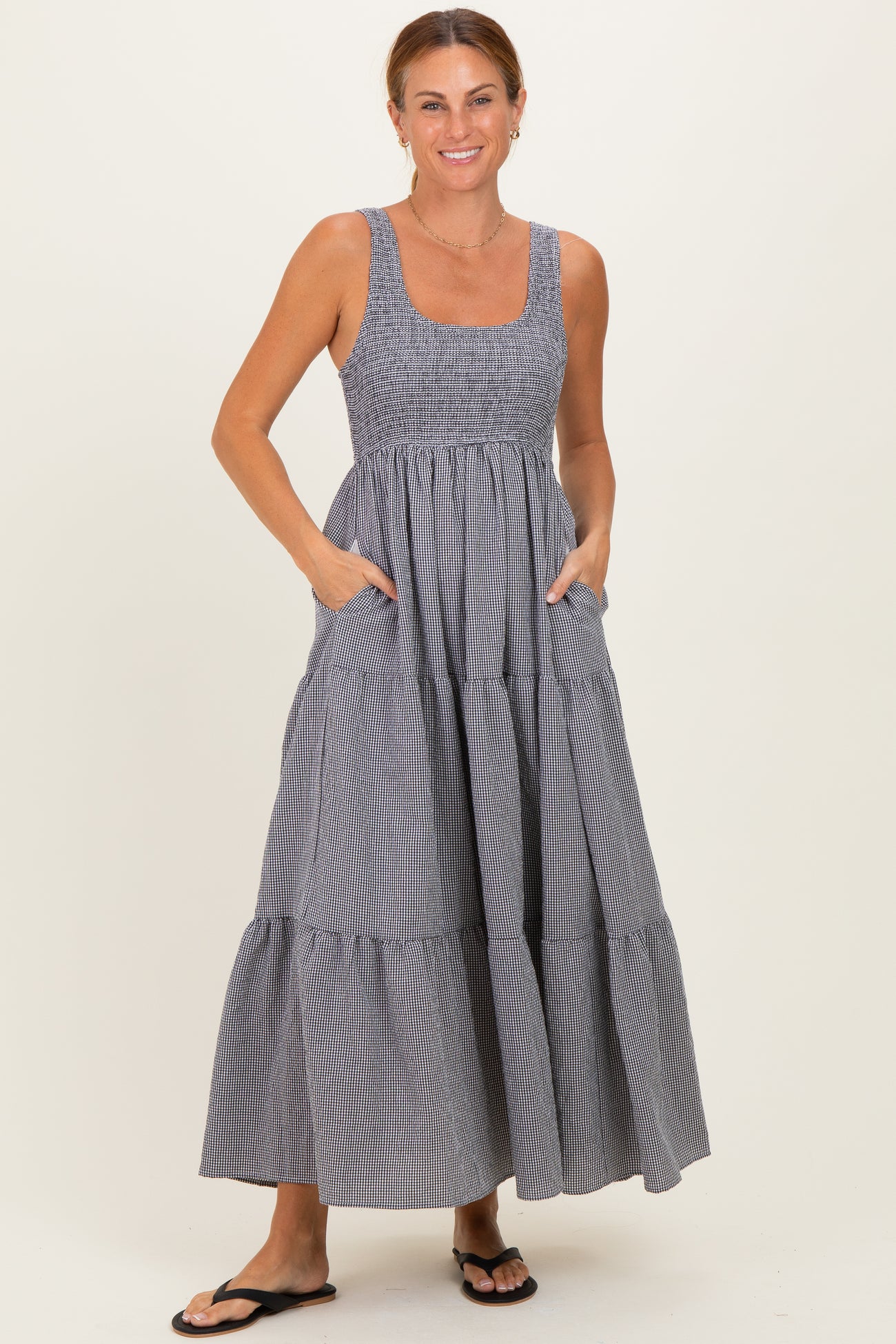 woman wearing a navy and white striped maxi dress with a smocked bodice and pockets