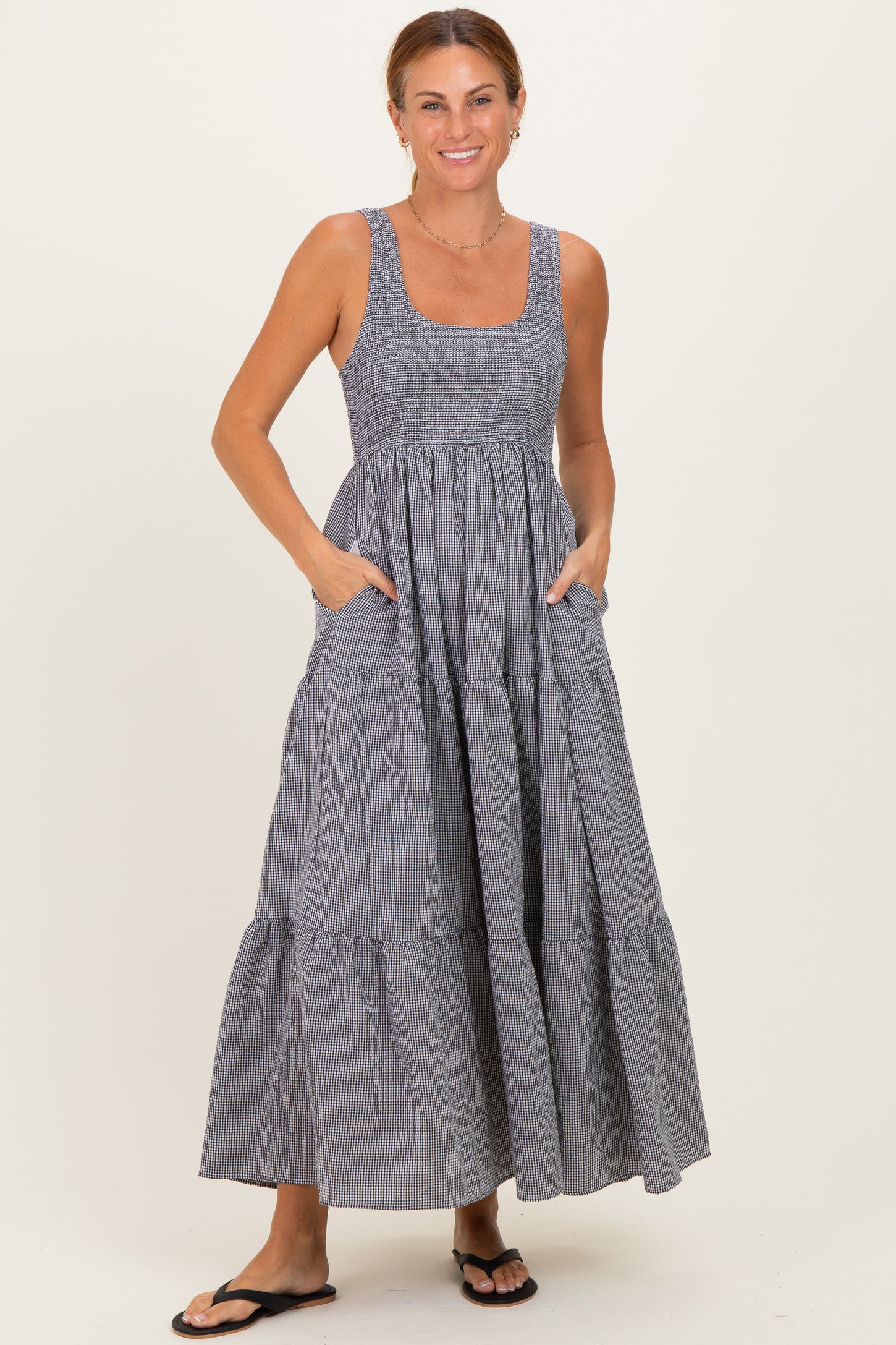 woman wearing a navy and white striped maxi dress with a smocked bodice and pockets