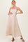 woman wearing a blush pink floral maternity maxi dress and holding her baby bump