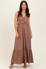 woman wearing a brown sleeveless maxi dress with a ruffled waist and flared hem