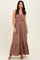 woman wearing a brown sleeveless maxi dress with a ruffled waist and flared hem