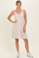 woman wearing a striped sleeveless sundress with a v-neckline and white sneakers