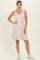 woman wearing a striped sleeveless sundress with a v-neckline and white sneakers