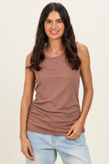 woman wearing a brown ribbed tank top with a fitted silhouette and ruched detailing, paired with light blue jeans