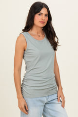 woman wearing a light green ribbed tank top with gathering detail at the sides and styled with light blue jeans