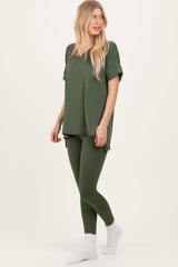 woman wearing an olive green oversized t-shirt and matching leggings, styled with white socks