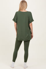 woman wearing an oversized green t-shirt with rolled sleeves and matching green leggings, viewed from the back