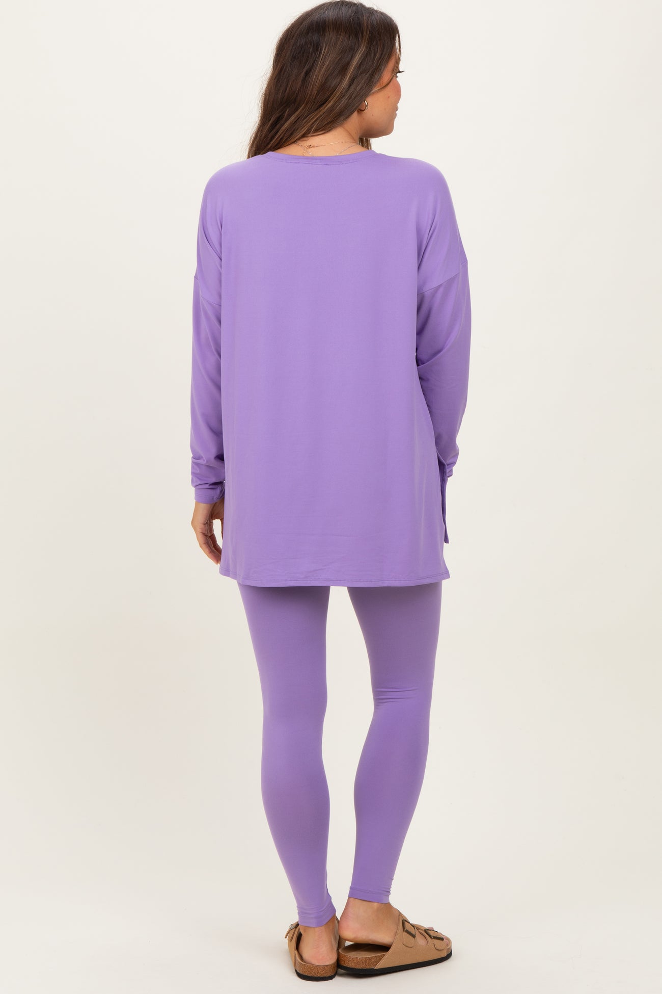 woman wearing a purple long sleeve maternity top and matching leggings, showing her back with relaxed fit