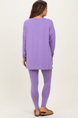 woman wearing a purple long sleeve maternity top and matching leggings, showing her back with relaxed fit