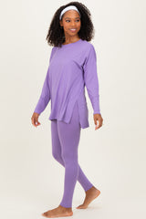 woman wearing a purple long sleeve top and matching leggings, styled for an active leisure look