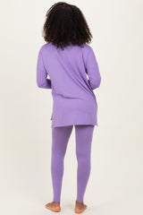 woman wearing a long purple tunic top and matching purple leggings, viewed from the back