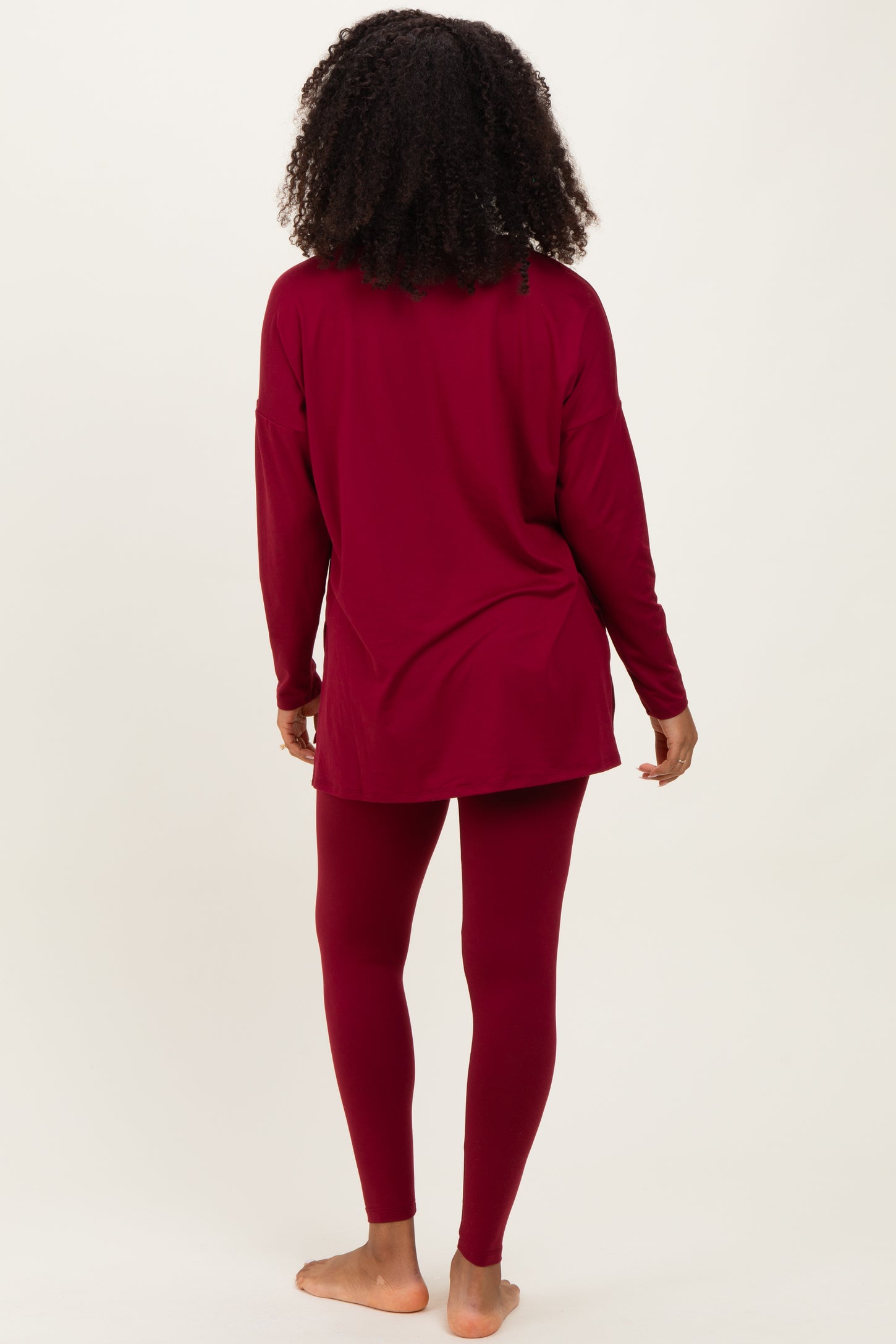 woman wearing a burgundy long sleeve tunic top with matching leggings, seen from the back