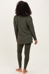woman wearing a dark green long sleeve top and matching leggings, seen from the back
